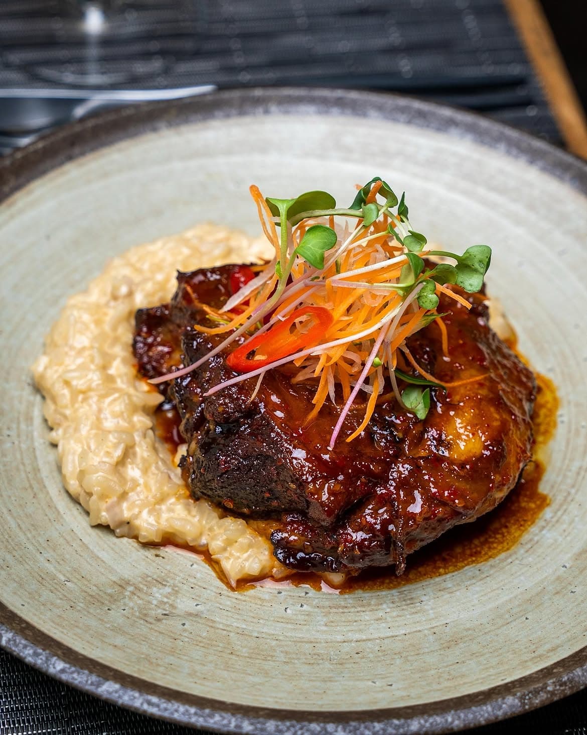 Miso marinated grilled lamb chops, slow-roasted, over creamy risotto with pickled vegetables.