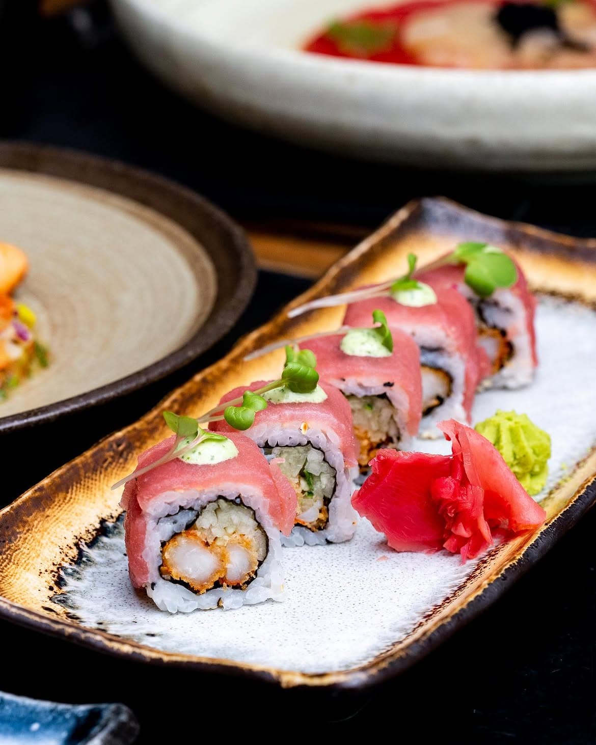 Spicy tuna roll wrapped with seared tuna, topped with wasabi cream and pickled ginger.